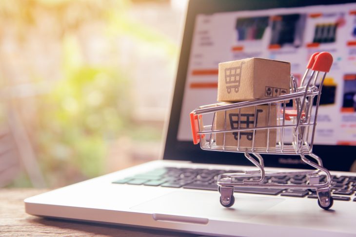 Shopping online concept – Parcel or Paper cartons with a shopping cart logo in a trolley on a laptop keyboard. Shopping service on The online web. offers home delivery.